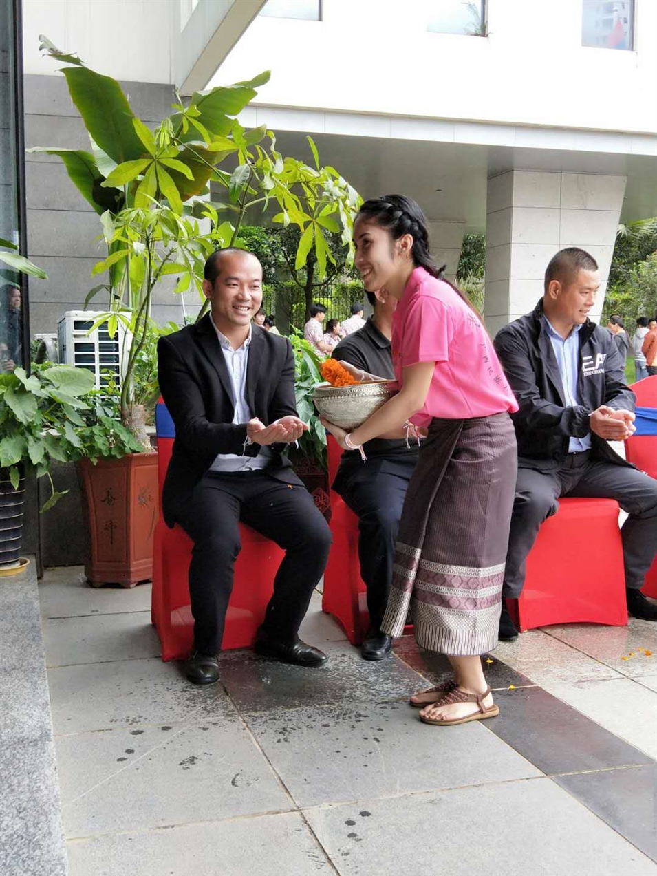 老撾駐廣西留學(xué)生代表將浸有花瓣的香水灑客人的手上，表示對嘉賓的美好祝福（圖一）
